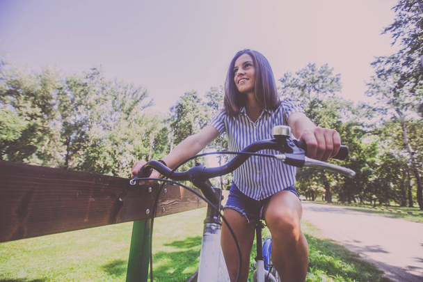 Mujer bastante joven montando bicicleta en el parque
  - Foto, imagen