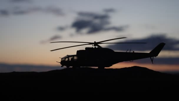 Silueta de helicóptero militar lista para volar desde zona de conflicto. Imágenes nocturnas decoradas con helicóptero comenzando en el desierto con niebla tonificada retroiluminada. Enfoque selectivo
. - Metraje, vídeo