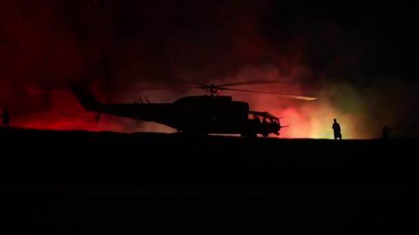 Silhouet van militaire helikopter klaar om te vliegen vanaf conflictgebied. Nacht beelden versierd met helikopter starten in woestijn met mistige afgezwakt achtergrondverlichting. Selectieve aandacht. - Video