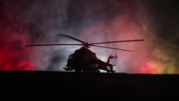 軍用ヘリコプター紛争地帯からを飛行する準備ができてのシルエット。霧のトーン バックライト付きの砂漠で始まるヘリコプター飾られて夜の映像。選択と集中. - 映像、動画