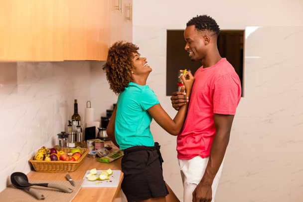 Black African American couple preparing food in the kitchen - Фото, изображение