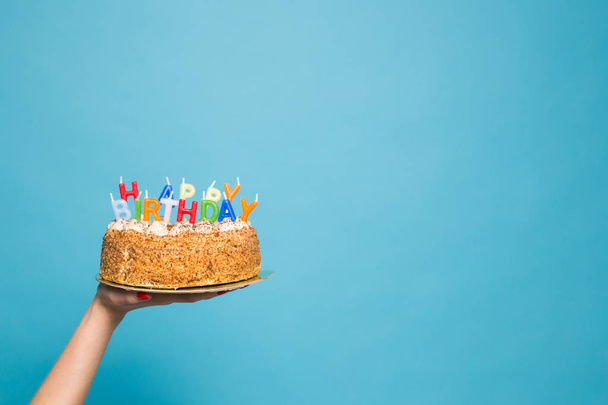 Eller mavi bir arka planda mumlar ve yazıt Doğum günü ile bir Doğum günü pastası tutarak. Kopyalama alanı - Fotoğraf, Görsel
