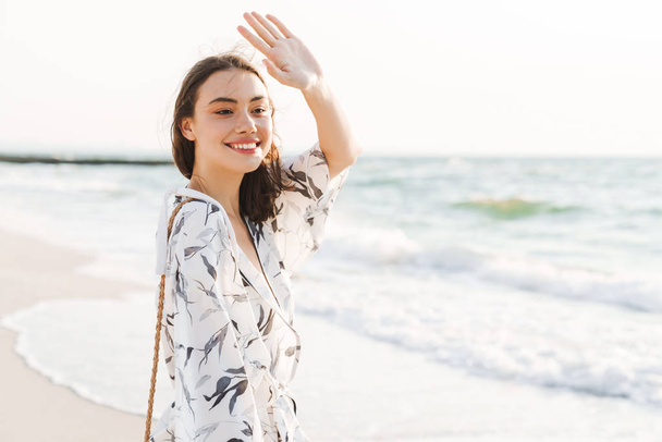 Cheery positive happy young beautiful woman at the beach walking in a beautiful sunny morning. - Valokuva, kuva