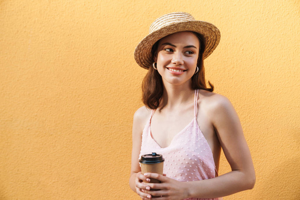 Photo closeup of beautiful young woman wearing summer straw hat  - Foto, Bild