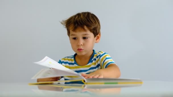 hidasliikkeinen aasialainen lapsi lukee kirjaa olohuoneessa. Hauskaa ja innoissaan tai kiinnostunut kirja tarinoita onnea hymyillen, nauraa kasvot
. - Materiaali, video