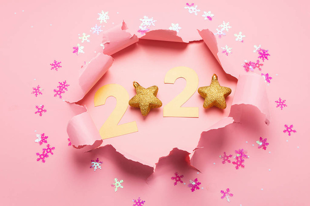 Le symbole de la nouvelle année à partir du numéro 2020 et un trou sur un fond de papier rose. Du papier déchiré. Concept Nouvel An
. - Photo, image