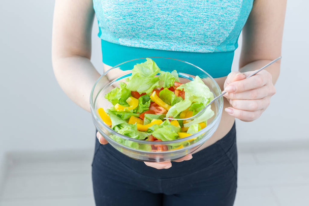 Terveellisen elämäntavan ja ruokavalion käsite - lähikuva naisesta, joka näyttää kasvissalaattia
 - Valokuva, kuva
