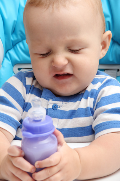 Bebê com garrafa de leite infeliz
 - Foto, Imagem