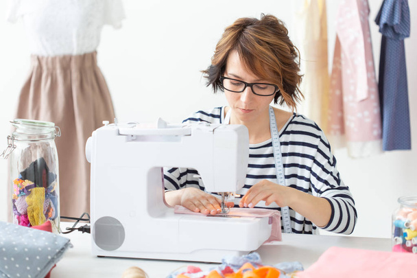 clothing designer, seamstress, people concept - clothing designer working in her studio - Photo, Image