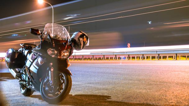 мотоцикл стоїть на дорожньому шоломі, що звисає на дзеркальних вогнях від прохідних автомобілів
 - Фото, зображення