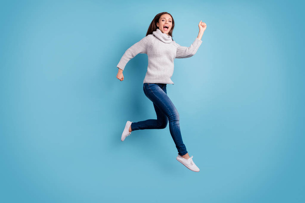Bargain. One minute - i am here. Full body photo of cute content teen youth jump run feel excited scream wear white knitted pullover sweater denim jeans sneakers isolated over blue color background - Фото, зображення