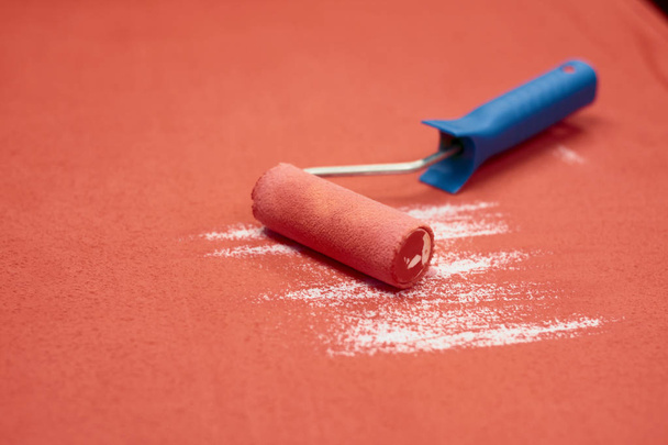 Roller paint with handle on a red background - Photo, Image