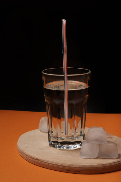 Glass of water with straw on wooden board - Photo, Image