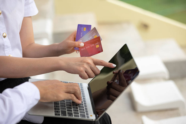 Ενθουσιασμένοι νεαρό ζευγάρι αγορές σε απευθείας σύνδεση, κρατώντας πιστωτική κάρτα και τον έλεγχο των πληροφοριών στην οθόνη του φορητού υπολογιστή - Φωτογραφία, εικόνα
