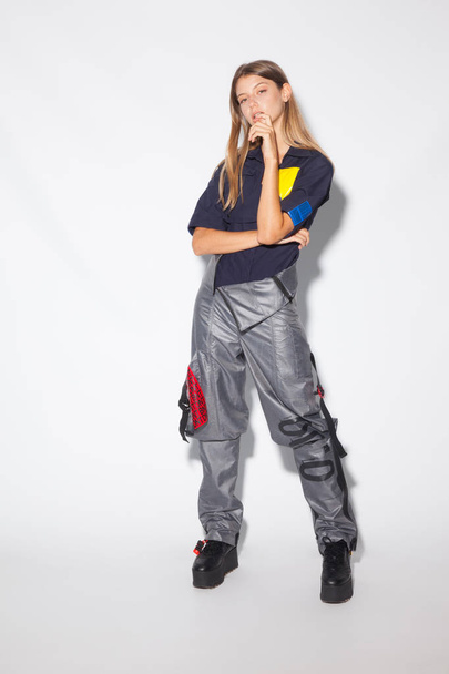Beautiful girl, model with futuristic urban clothes, expressions of a beautiful girl on white background - Valokuva, kuva