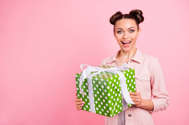Portrait of her she nice-looking attractive charming lovely cute winsome cheerful cheery glad delighted girl holding in hands dotted box isolated over pink pastel background - 写真・画像
