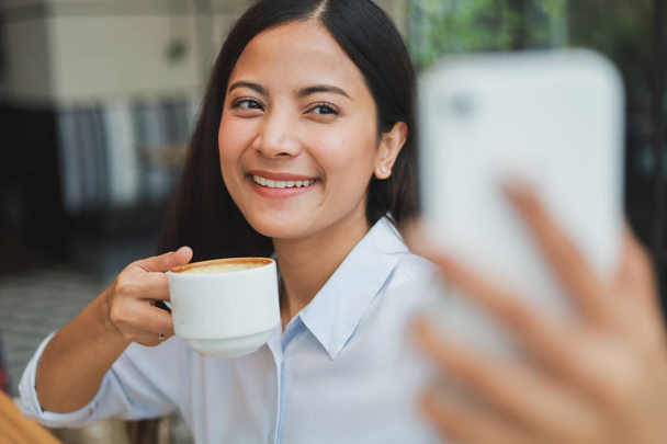 Asian woman selfie with mobile phone in coffee shop cafe smile a - Φωτογραφία, εικόνα