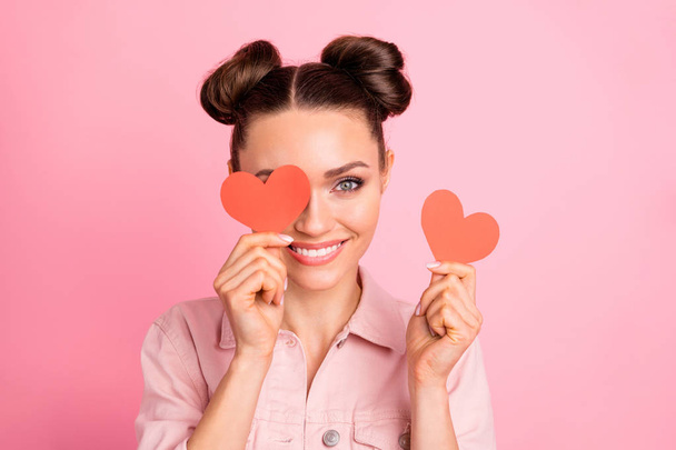 Portrait of lovely youth holding papercard heart looking with toothy smile wearing jacket isolated over pink background - Foto, Bild