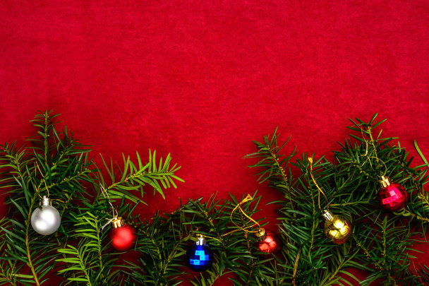 Kawałek papieru na życzenia świąteczne na czerwonym tle z gałęzi choinki i bombki. - Zdjęcie, obraz