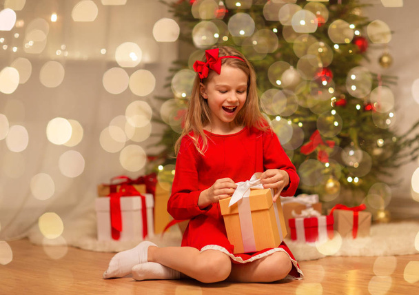smiling girl with christmas gift at home - Foto, imagen