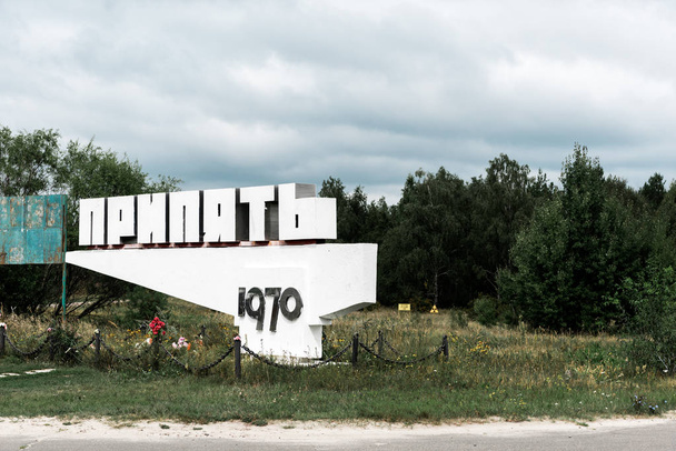 PRIPYAT, UKRAINE - AUGUST 15, 2019: monument with pripyat letters near trees outside  - Foto, Bild