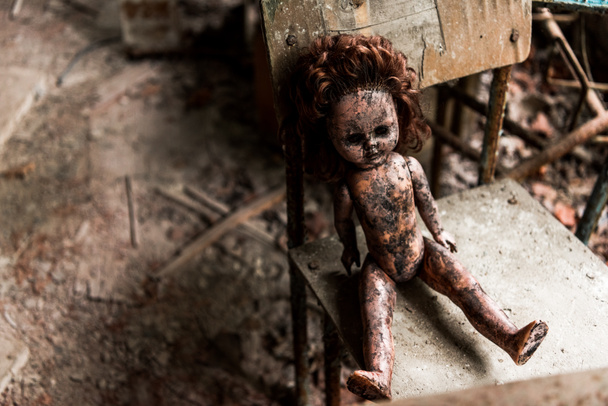 sujo e queimado bebê boneca na cadeira de madeira na escola
  - Foto, Imagem