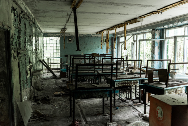 aula abandonada y espeluznante con mesas sucias en la escuela
  - Foto, imagen