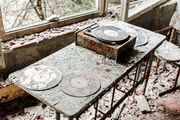 部屋の汚れたテーブルの上に放棄されたビニールレコード  - 写真・画像
