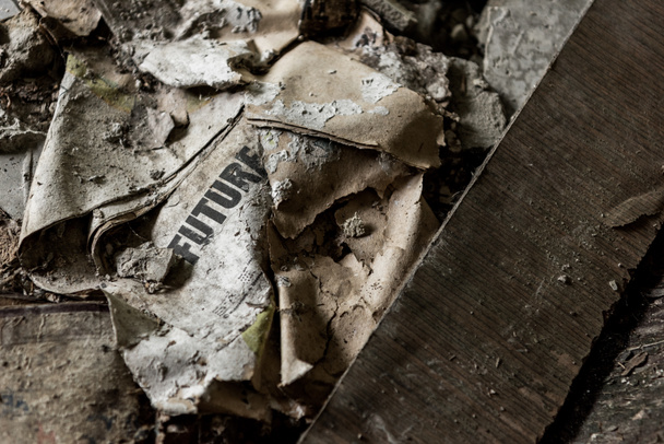 Καμένη εφημερίδα με μελλοντικές γράμματα σε βρώμικο πάτωμα  - Φωτογραφία, εικόνα