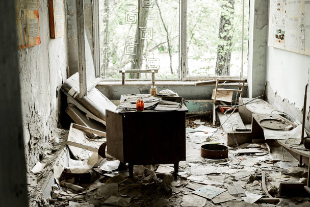 PRIPYAT, UKRAINE - AUGUST 15, 2019: abandoned and damaged room with papers and documents on floor  - Фото, зображення