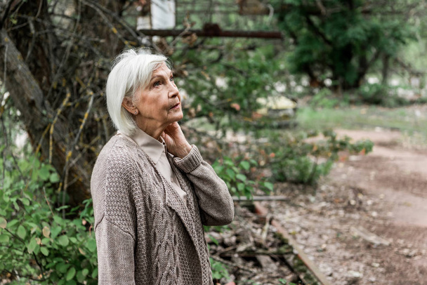 Seniorin steht im grünen verlassenen Park  - Foto, Bild