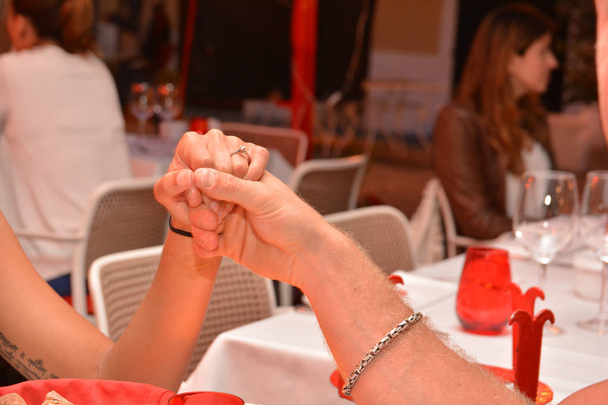 Dwóch kochanków na grzywny stolik po zobowiązaniu się do pierścieni. - Zdjęcie, obraz