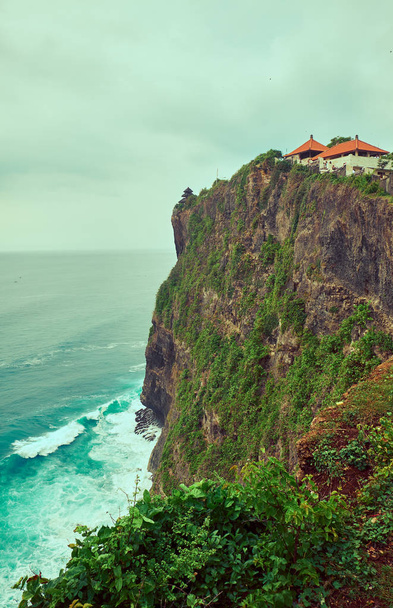 Uluwatu Temple on a cliff near the ocean.  - Fotó, kép