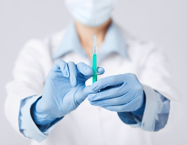 Female doctor holding syringe with injection - 写真・画像
