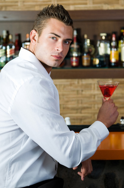 Beautiful man drinking red martini - Foto, Bild