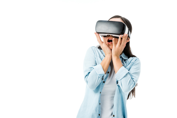 shocked woman in denim shirt with virtual reality headset isolated on white  - 写真・画像