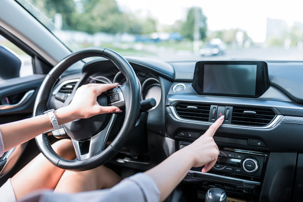 Zbliżenie, Kobieta ręka zawiera przycisk zatrzymania awaryjnego, Włączanie wymiarów, wypadek na drodze. Wnętrze samochodu w lecie w mieście, alarm i wypadki na autostradzie. - Zdjęcie, obraz