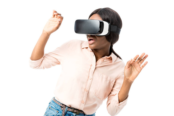 chocado afro-americano mulher na camisa com realidade virtual fone de ouvido isolado no branco
  - Foto, Imagem