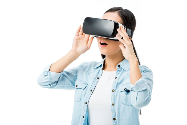 shocked woman in denim shirt with virtual reality headset isolated on white  - Foto, Bild