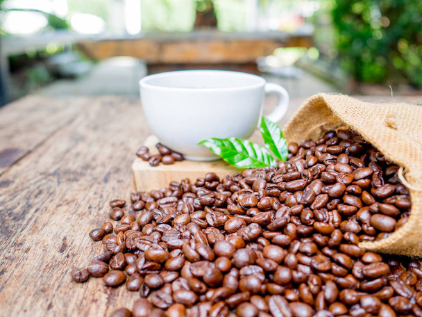 Кофейные зерна выливаются из мешка, готовые придать свежесть и вместе с бизнесменом
 - Фото, изображение