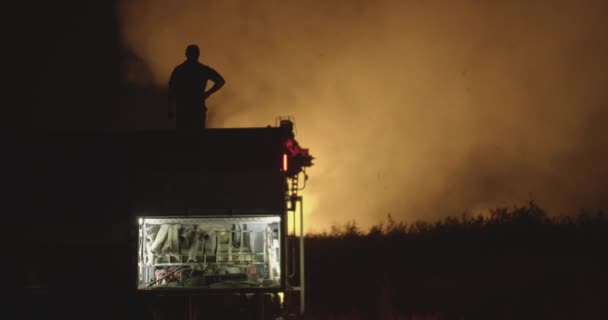 Tűzoltókocsi a villogó fény a háttérben égő területen. - Felvétel, videó