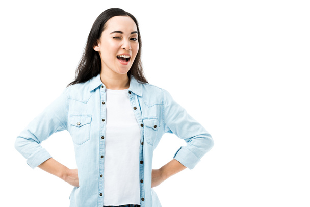 attrayant et souriant asiatique femme en denim chemise clin d'oeil isolé sur blanc
  - Photo, image