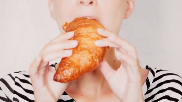 portré kaukázusi nő eszik croissant - Felvétel, videó