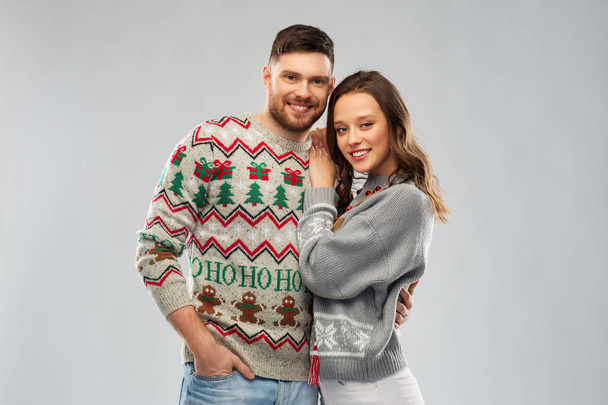 happy couple at christmas ugly sweater party - Фото, изображение