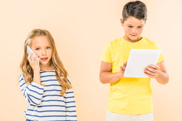 two kids using smartphone and digital tablet isolated on pink - Foto, Bild