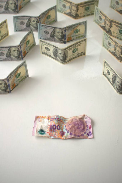 Ekonomická krize v Argentině a devalvace měny. Zmačkané argentinské bankovky a nedotčené bankovky USA. Metafora konceptu. - Fotografie, Obrázek