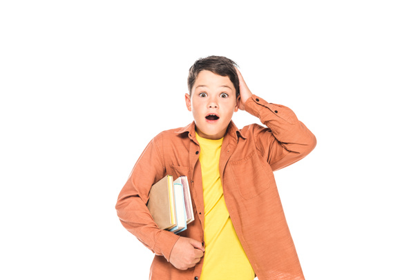 front view of shocked kid holding books isolated on white - Fotó, kép