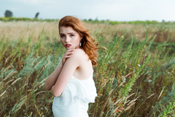 beautiful redhead woman in white dress looking at camera  - Foto, imagen