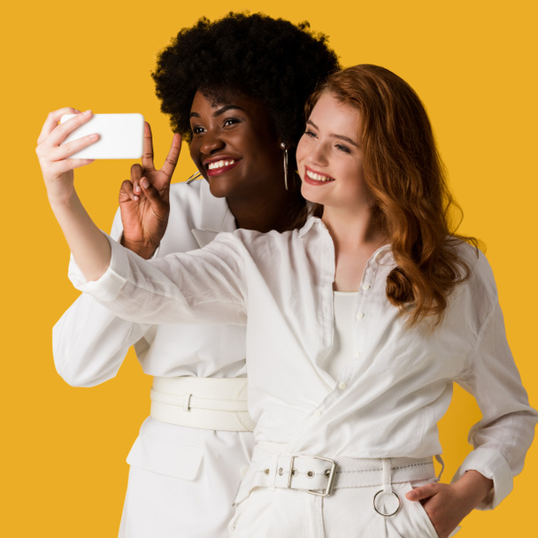 heureux multiculturel filles prendre selfie isolé sur orange
  - Photo, image