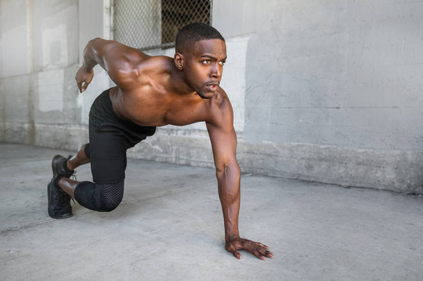 Shirtless male african american athlete training in urban city concrete background, sprinter, runner, jogger, muscular toned build training for race - Photo, Image